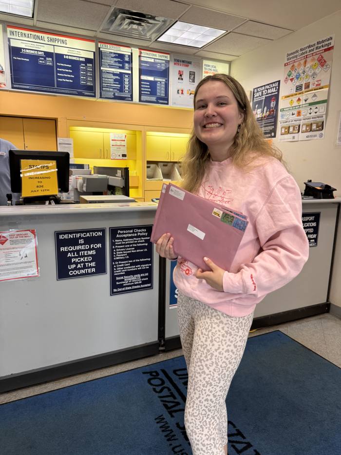 Brooke Shupp mailing Pages of Purple outreach materials at the post office.
