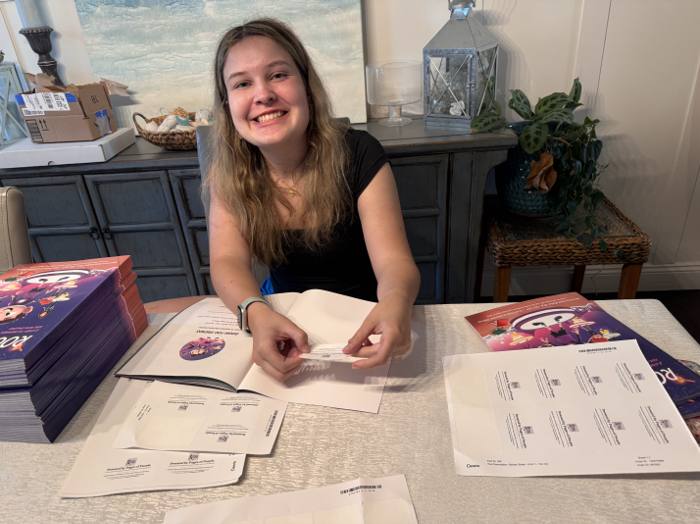 Brooke Shupp adding Pages of Purple labels to Room for Friends books.