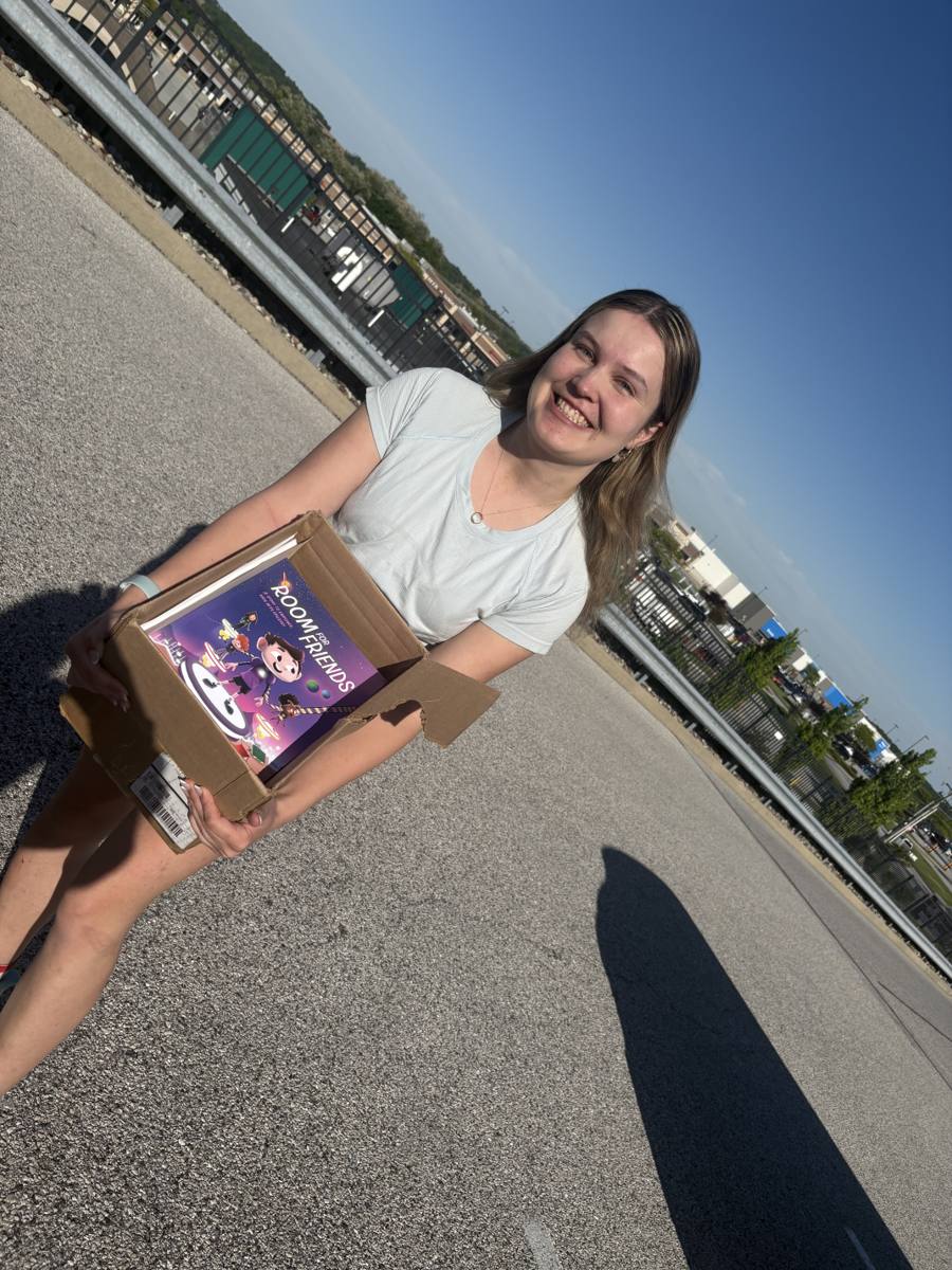 Brooke Shupp holding a box of Room for Friends books for campaign outreach.